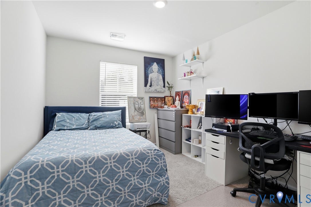 Carpeted room with a window featuring horizontal blinds