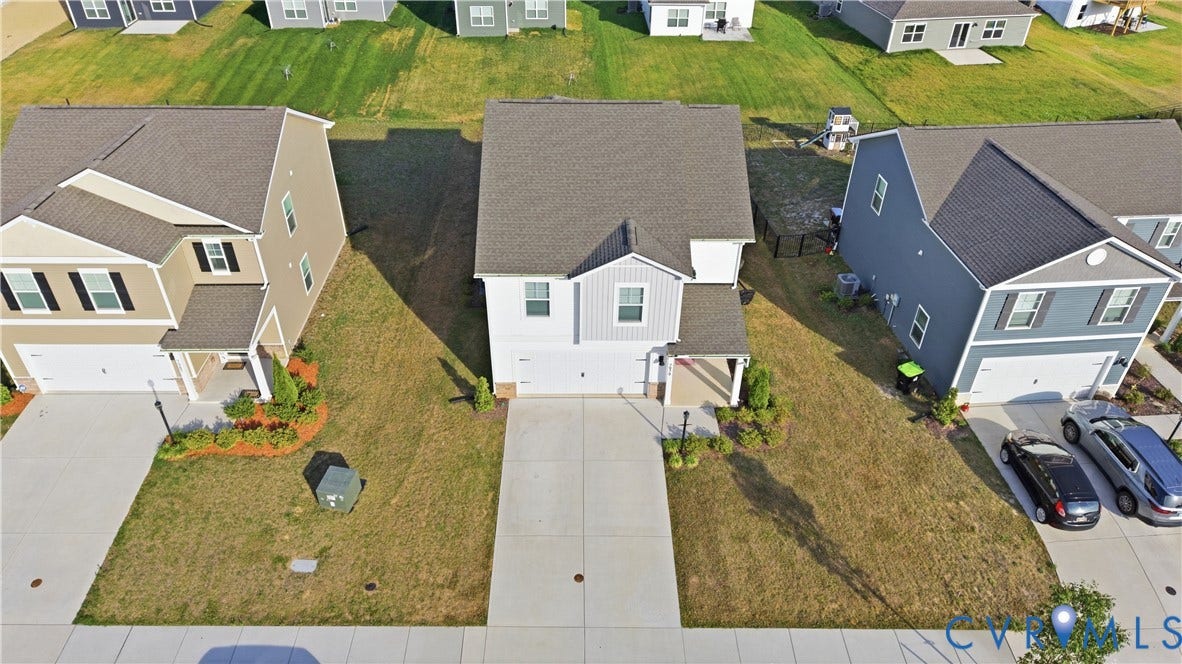 Two-story residence featuring a covered front porch, an attached garage, and a concrete driveway