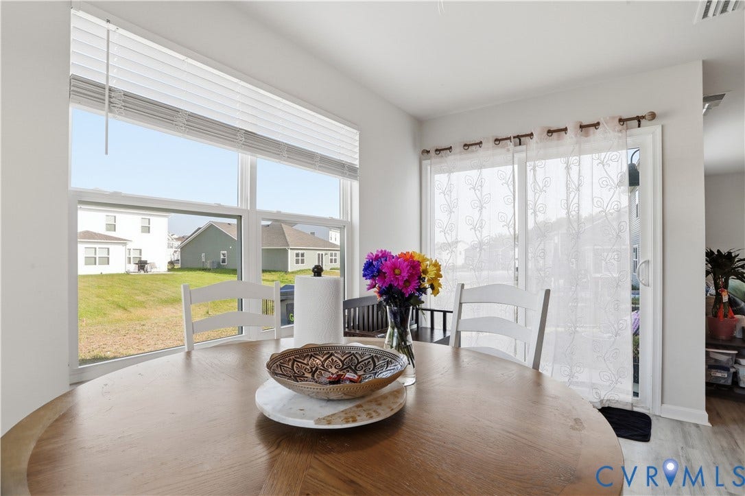 Breakfast nook featuring a large picture window, wood-finish flooring, and a sliding glass door