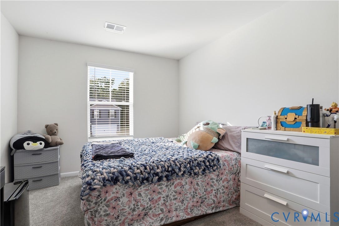 Bedroom featuring neutral wall paint, carpet flooring, a window with horizontal blinds, and a ceiling vent