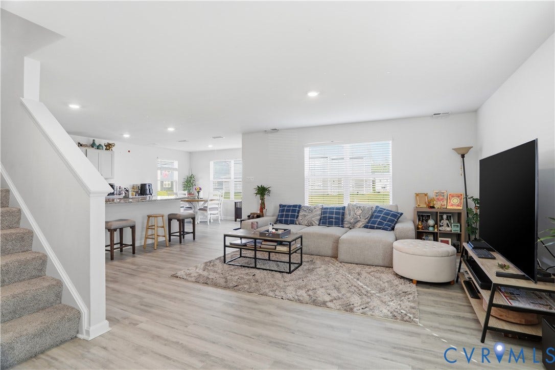 Open-concept living area featuring light wood-finish flooring, recessed lighting, and white baseboards