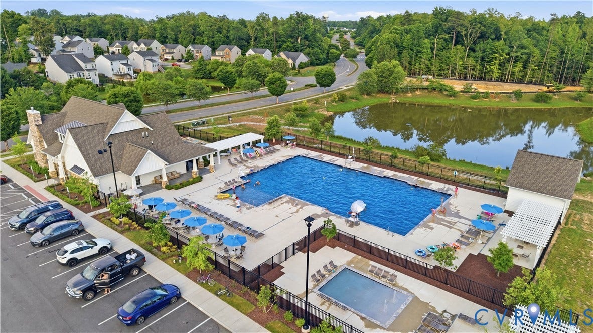 Community clubhouse with an outdoor swimming pool, adjacent wading pool, and sun deck seating