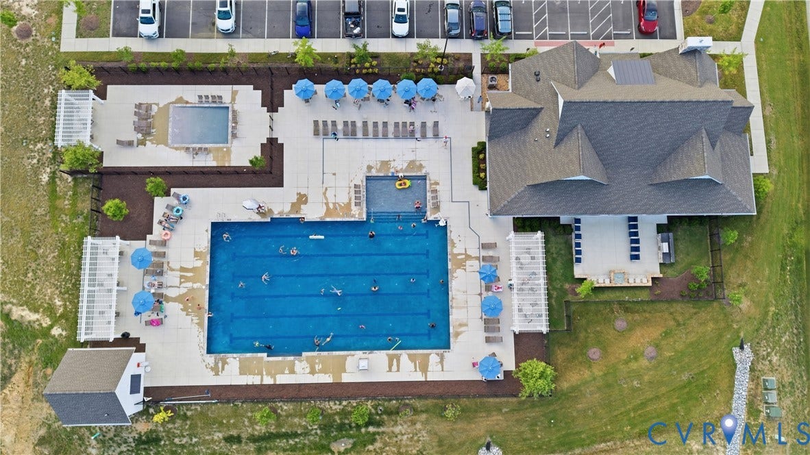 Expansive community pool area featuring a large rectangular swimming pool and a separate smaller pool