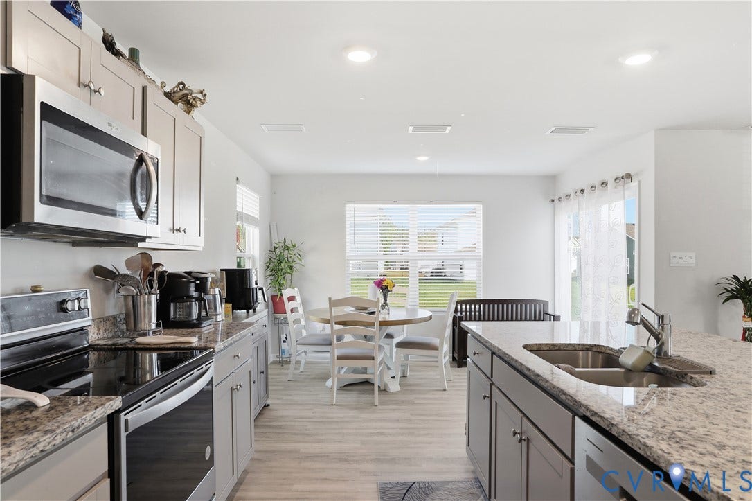 Kitchen featuring light-toned cabinetry, stainless steel appliances, granite countertops, and recessed lighting