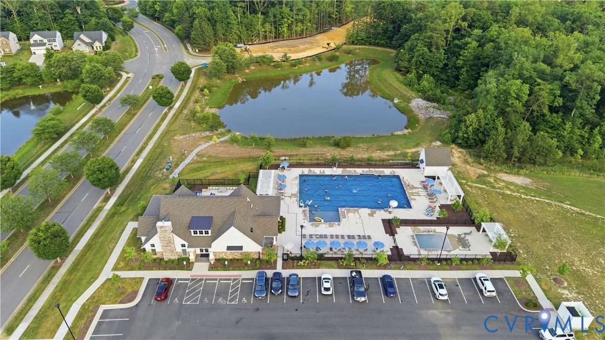 Community clubhouse featuring a large outdoor swimming pool, a separate smaller pool, and a spacious surrounding deck