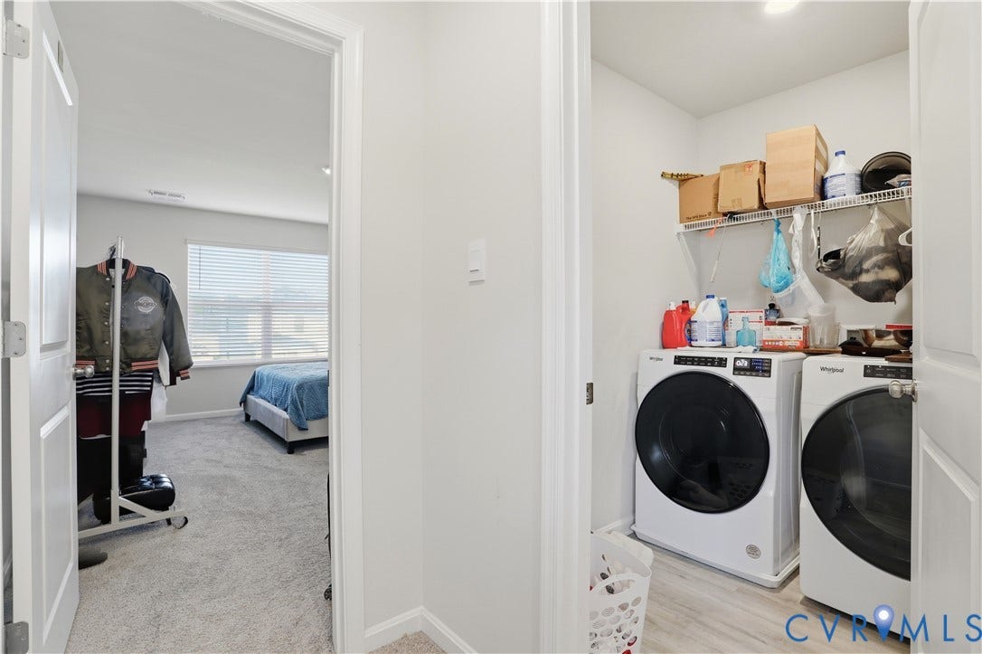 Dedicated laundry area featuring wood-finish flooring and wire shelving