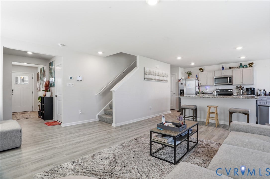 Open-concept living space with light-tone wood-finish flooring
