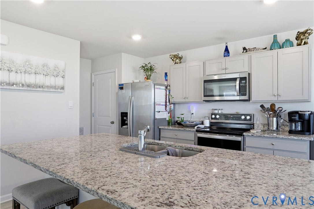 Kitchen featuring light-toned cabinetry and granite countertops