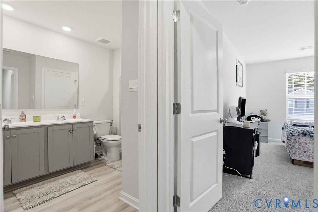 Bathroom featuring a double vanity with gray cabinetry, white countertops, and dual undermount sinks