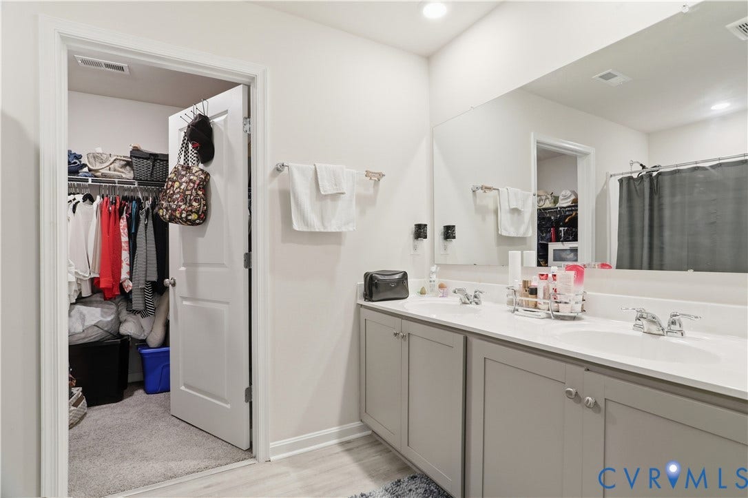 Bathroom featuring a dual vanity with light gray cabinetry and white countertops