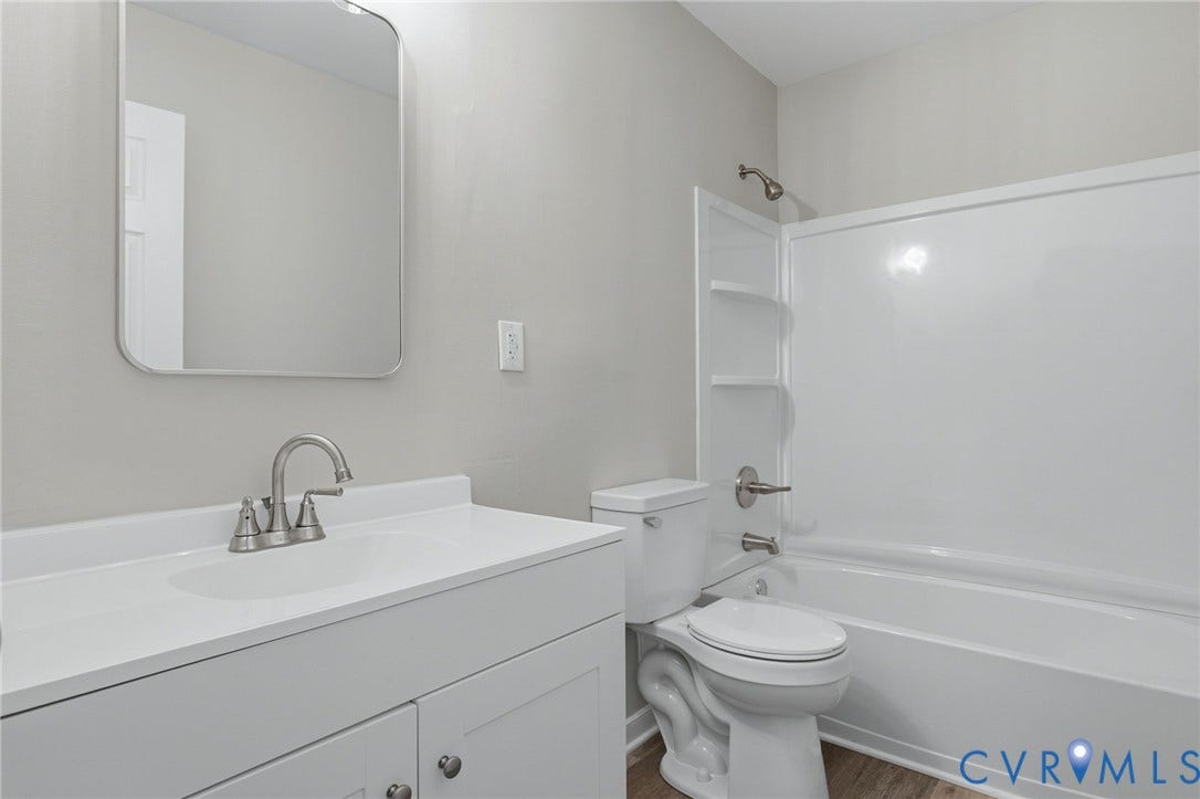 3218 Hunters Mill Court, Henrico, VA 23223 Bathroom featuring a white vanity with integrated sink, brushed nickel faucet, framed mirror, and a white tub/shower combination with built-in shelving
