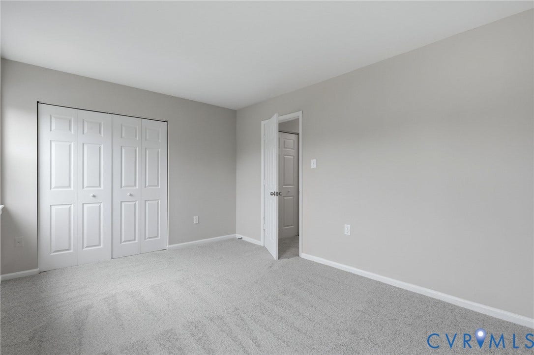 3218 Hunters Mill Court, Henrico, VA 23223 Spacious room featuring light gray carpeting, neutral wall paint, white baseboards, and a white bi-fold closet