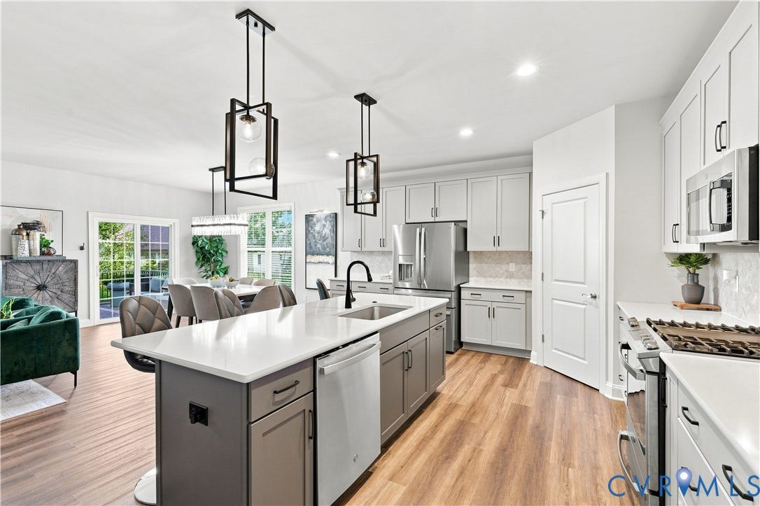 7437 Aldeby Street, Glen Allen, VA 23059 Gourmet kitchen with stainless steel appliances, white cabinetry, a large kitchen island, and wood-finish flooring