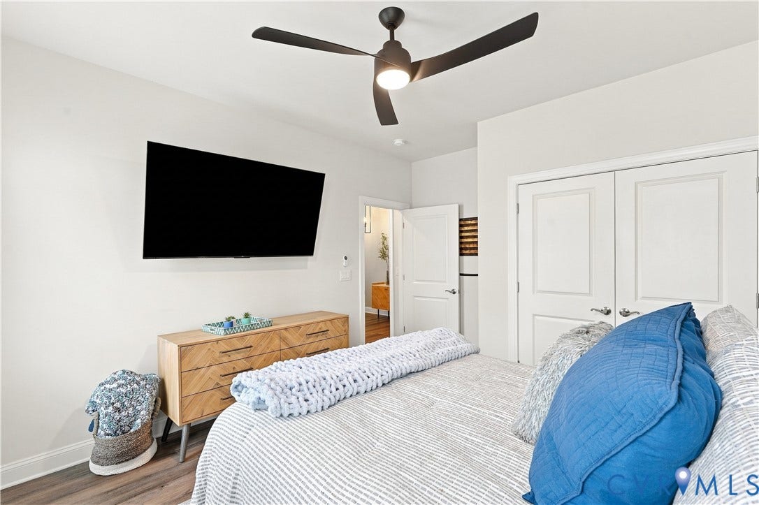 7437 Aldeby Street, Glen Allen, VA 23059 Matte black ceiling fan with integrated lighting, wood-finish flooring, and white paneled closet doors