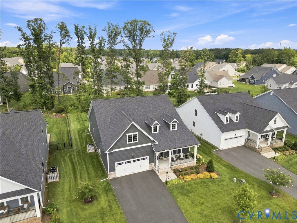 7437 Aldeby Street, Glen Allen, VA 23059 Modern home featuring a dark gray exterior, white trim, a covered front porch, and an attached two-car garage