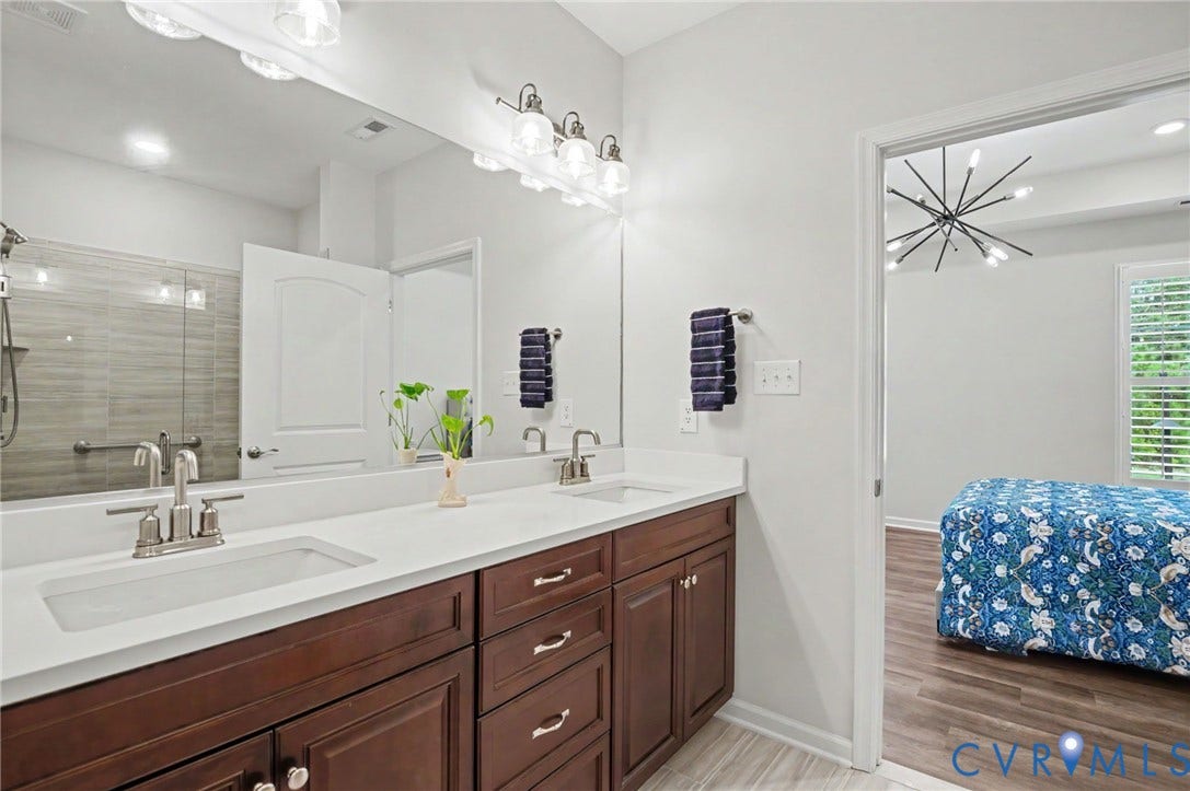 11618 Orchard Falls Circle, Chickahominy Falls, Glen Allen, VA 23059 Dual undermount sinks with brushed nickel fixtures, expansive vanity with wood-finish cabinetry, full-width mirror, and a tiled walk-in shower