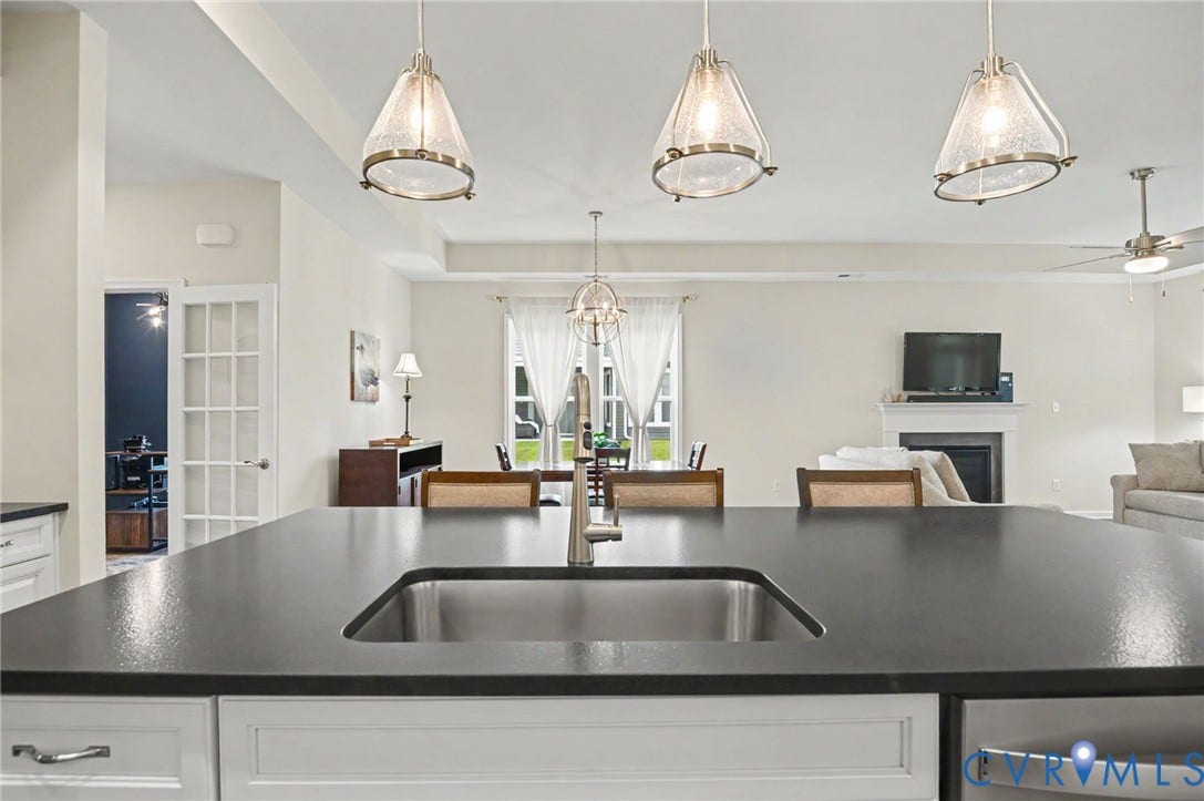 11618 Orchard Falls Circle, Chickahominy Falls, Glen Allen, VA 23059 Kitchen island with an undermount sink, white cabinetry, and pendant lighting