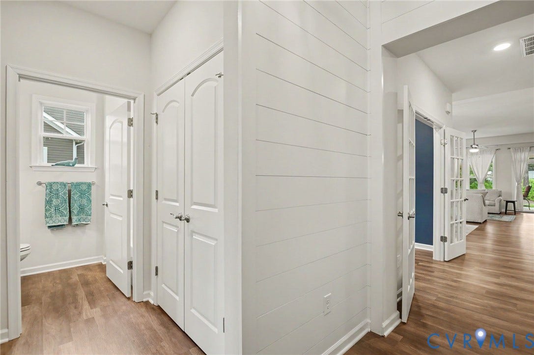 11618 Orchard Falls Circle, Chickahominy Falls, Glen Allen, VA 23059 Wood-finish flooring throughout, white shiplap accent wall, white paneled doors, and white French doors with glass panes