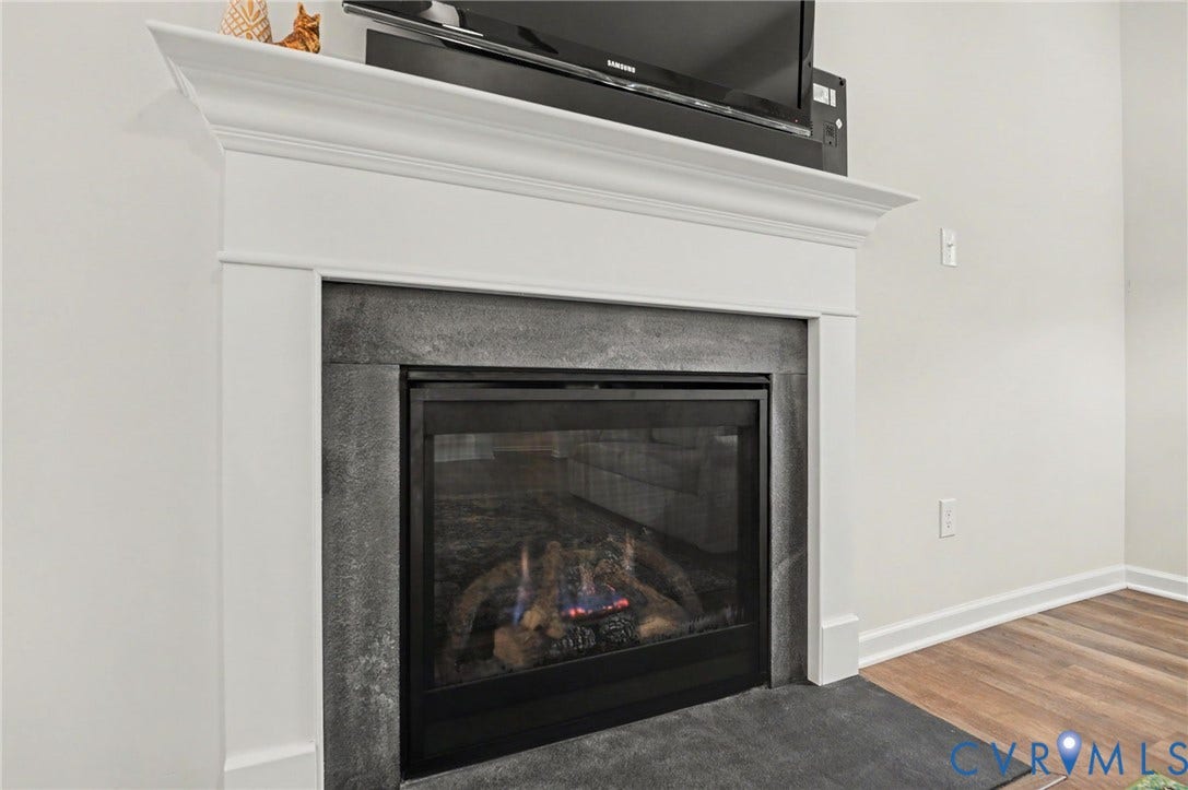 11618 Orchard Falls Circle, Chickahominy Falls, Glen Allen, VA 23059 Fireplace featuring a white mantel, dark stone surround, and glass enclosure