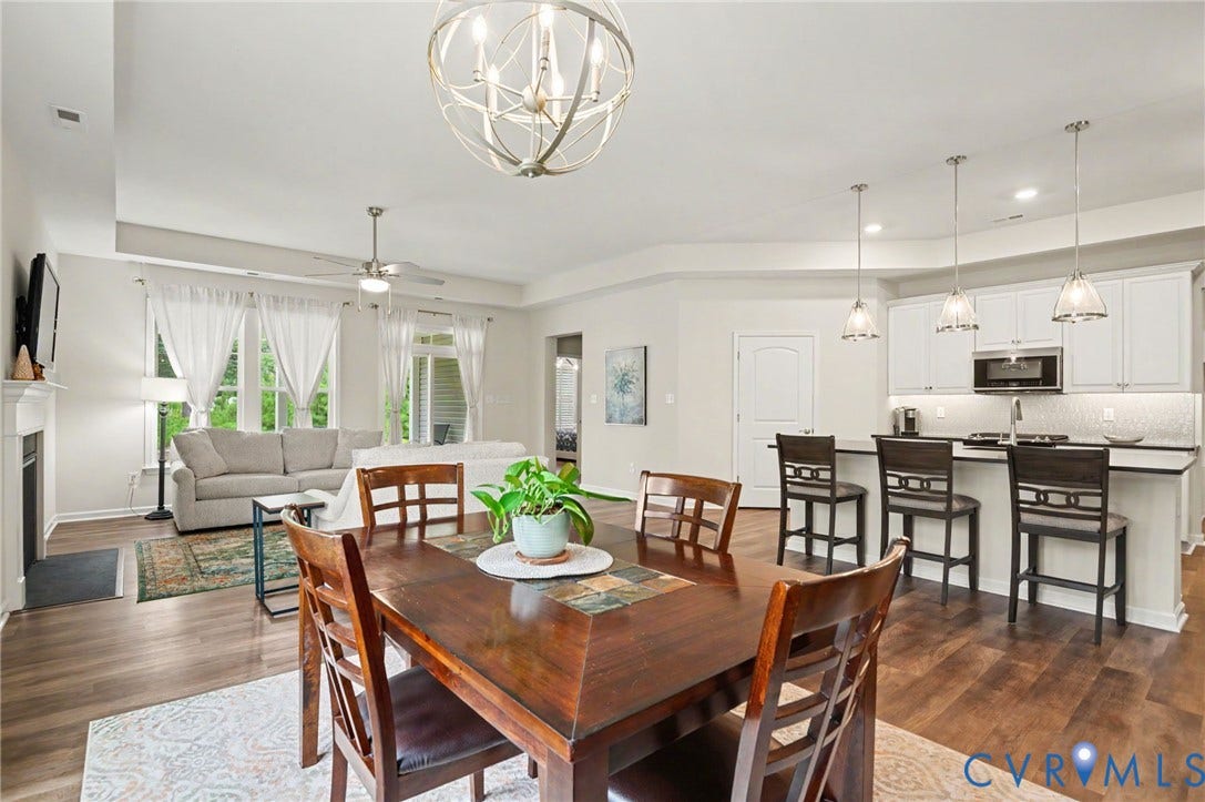 11618 Orchard Falls Circle, Chickahominy Falls, Glen Allen, VA 23059 Open-concept living space featuring wood-finish flooring, a contemporary kitchen with white cabinetry and stainless steel appliances, and a fireplace