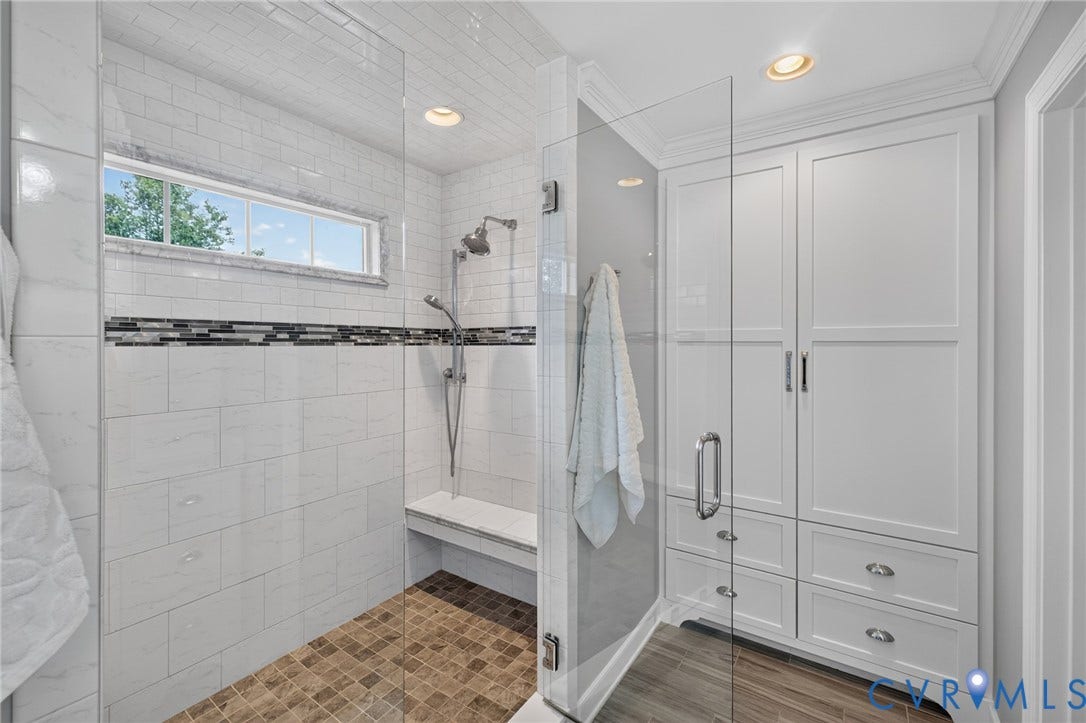 12320 Bradford Landing Way, Glen Allen, VA 23059 Walk-in shower featuring a fixed glass panel, subway tile surround with decorative accent band, integrated bench seat, and dual shower heads