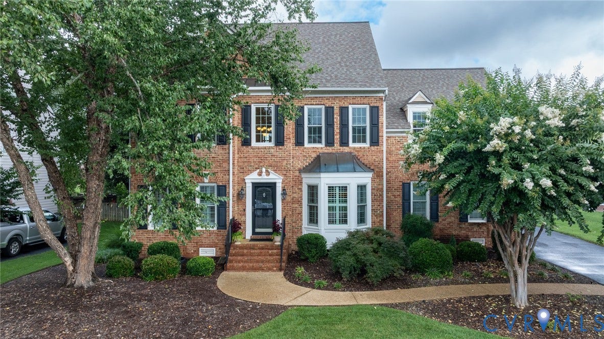 12320 Bradford Landing Way, Glen Allen, VA 23059 Brick facade residence featuring a prominent bay window, dark shutters, a front entry with sidelights, a gabled roofline, and established landscaping