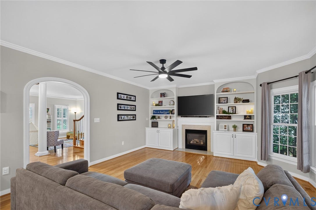 12320 Bradford Landing Way, Glen Allen, VA 23059 Living area featuring hardwood flooring, a built-in fireplace with a stone surround, and custom built-in shelving with cabinetry