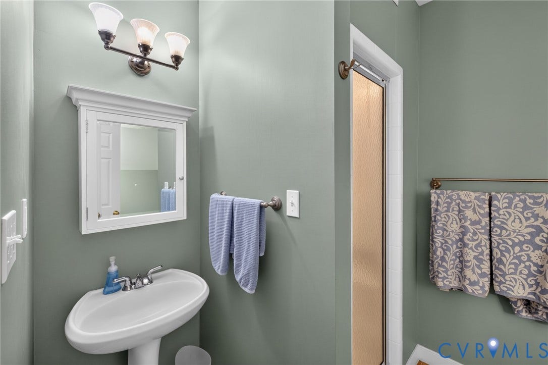 12320 Bradford Landing Way, Glen Allen, VA 23059 Bathroom featuring a pedestal sink, framed medicine cabinet, and a wall-mounted light fixture with three frosted glass shades