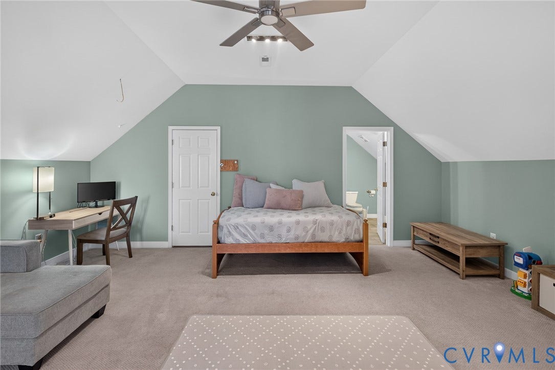 12320 Bradford Landing Way, Glen Allen, VA 23059 Spacious carpeted room featuring a ceiling fan with integrated lighting, a paneled door, and an entryway to a bathroom with a white toilet