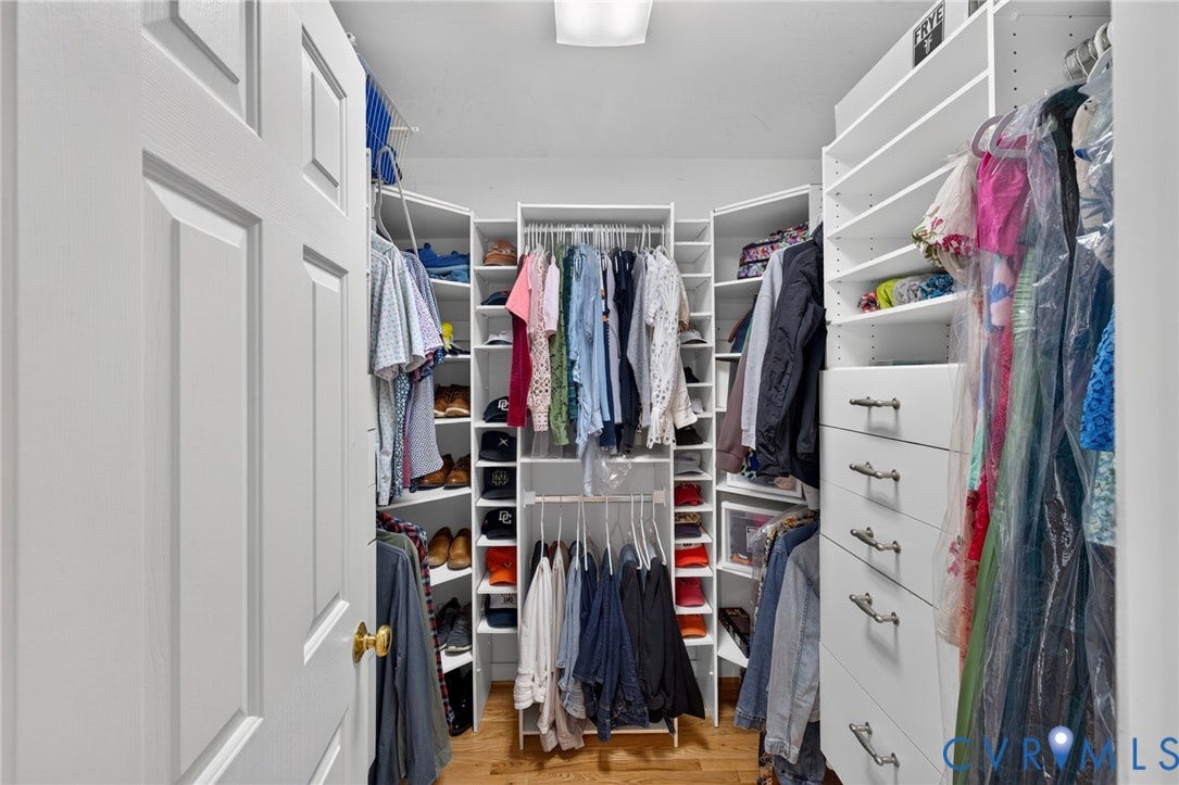 12320 Bradford Landing Way, Glen Allen, VA 23059 Walk-in closet featuring custom built-in shelving, multiple hanging rods, corner storage units, integrated drawers with brushed nickel hardware, and wood-finish flooring