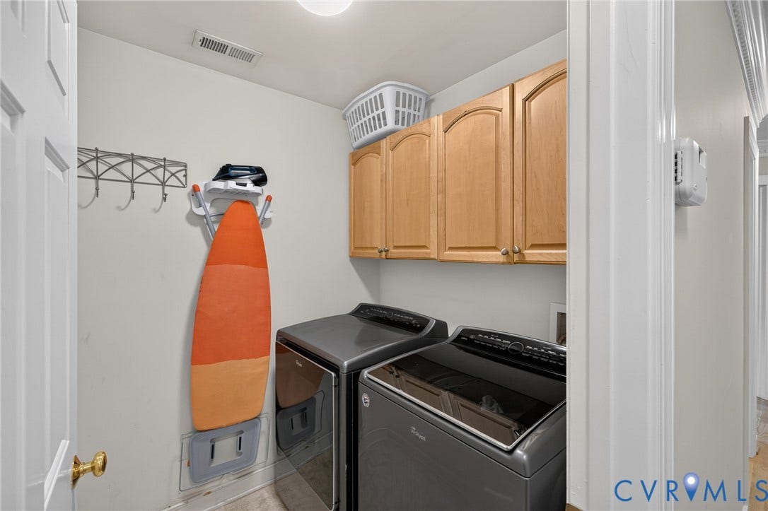 12320 Bradford Landing Way, Glen Allen, VA 23059 Dedicated laundry space featuring a side-by-side appliance configuration, wood-finish cabinetry, and neutral wall finishes