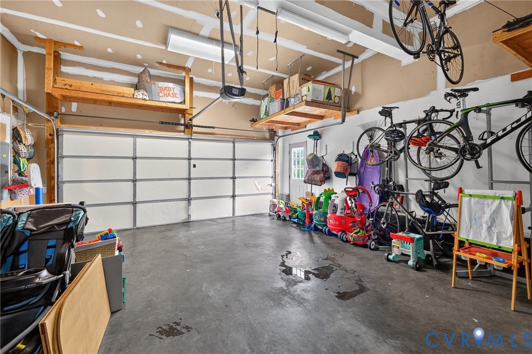 12320 Bradford Landing Way, Glen Allen, VA 23059 Spacious garage featuring a concrete floor, overhead shelving, and wall-mounted storage solutions
