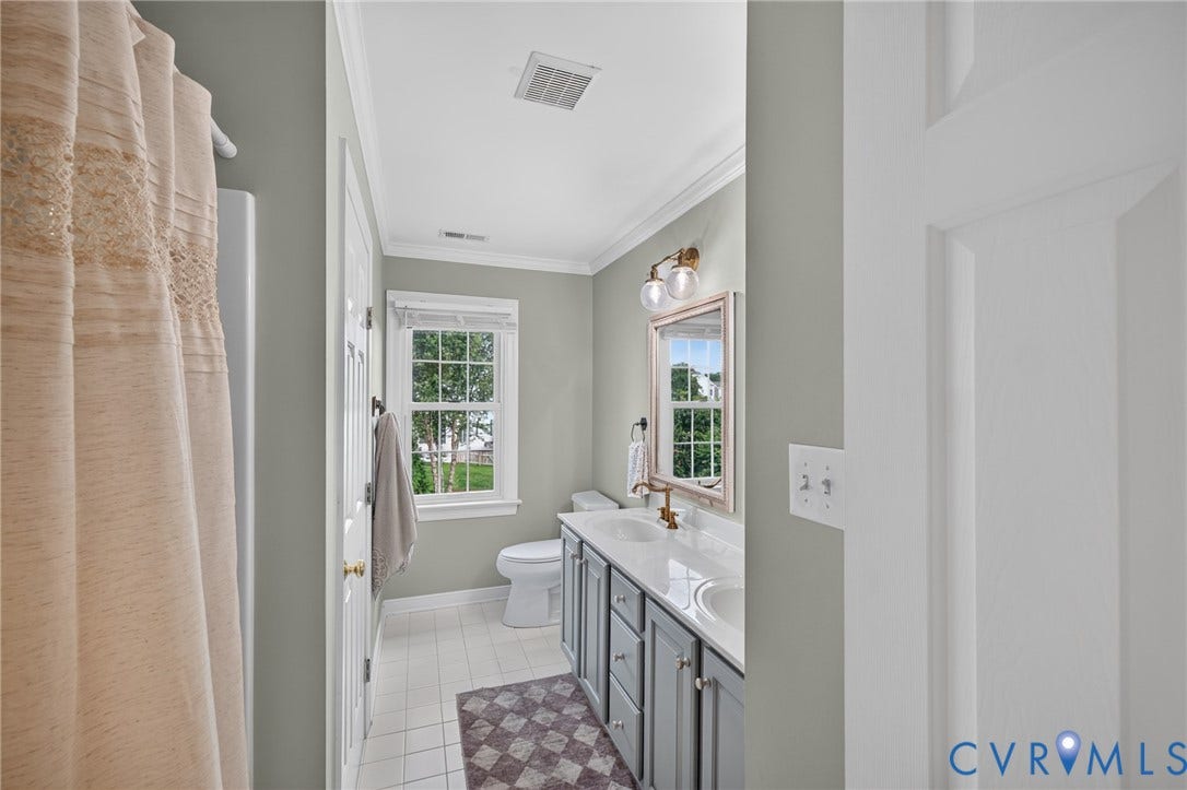 12320 Bradford Landing Way, Glen Allen, VA 23059 Bathroom featuring a dual vanity with a light-colored countertop, undermount sinks, and brass-finish fixtures