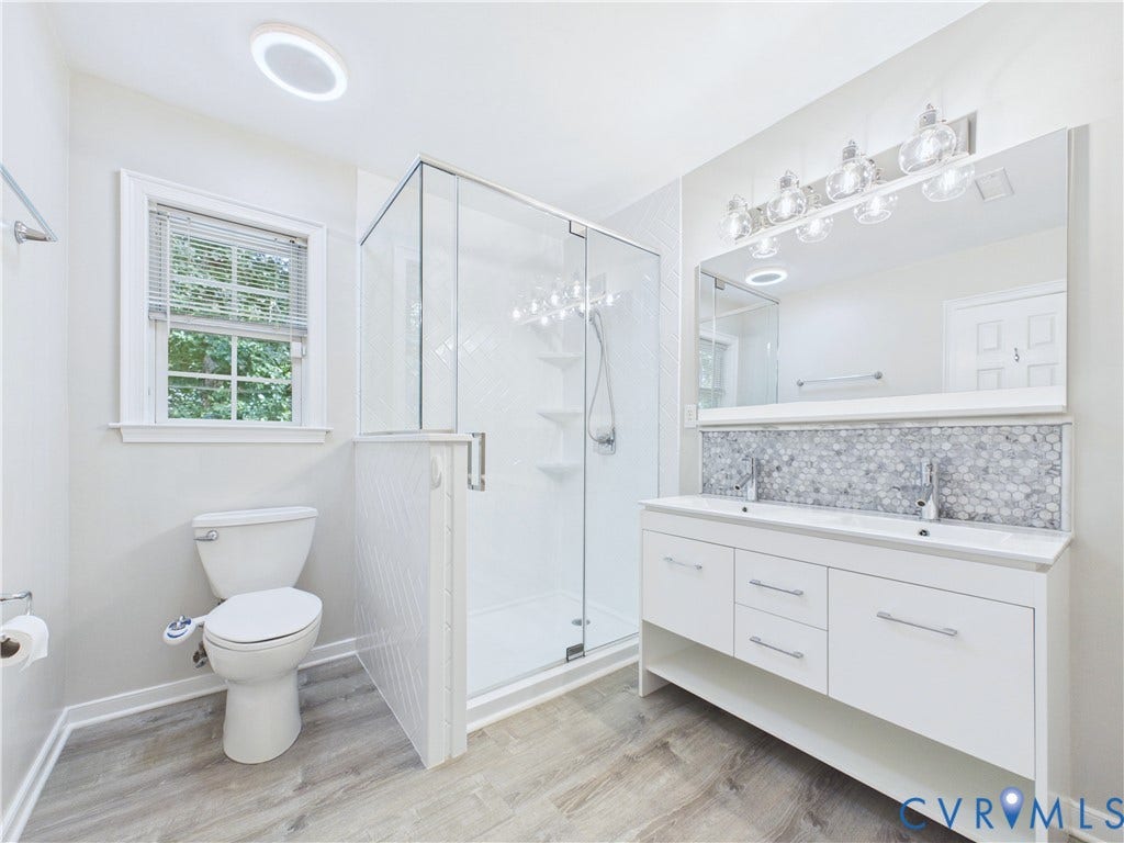 4515 Exton Lane, Chester, VA 23831 Dual sink vanity with white cabinetry, glass-enclosed shower, wood-finish flooring, recessed lighting, and a window with blinds
