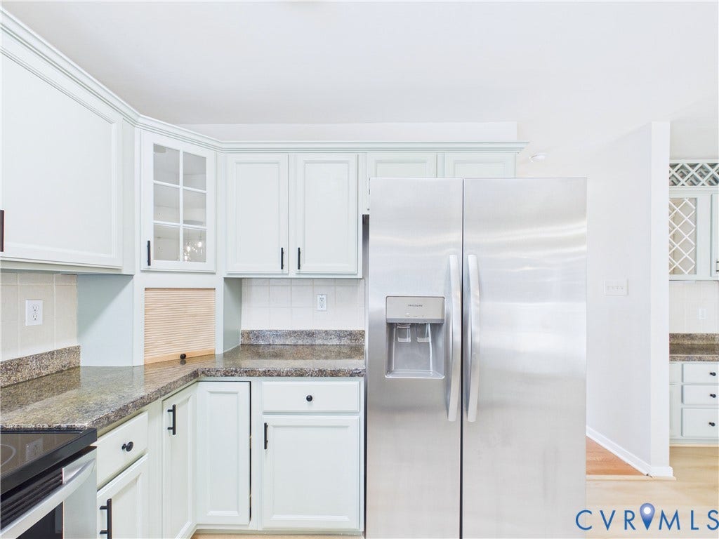 4515 Exton Lane, Chester, VA 23831 White cabinetry with black hardware, granite-style countertops, stainless steel side-by-side refrigerator, tile backsplash, and wood-finish flooring