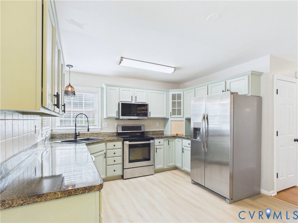 4515 Exton Lane, Chester, VA 23831 Kitchen featuring light-toned cabinetry, stainless steel appliances, dark countertop, light wood-finish flooring, and a window