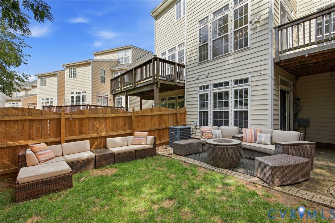 Private backyard featuring a paver patio with direct access to the interior via a sliding glass door, a wooden privacy fence, and a manicured lawn