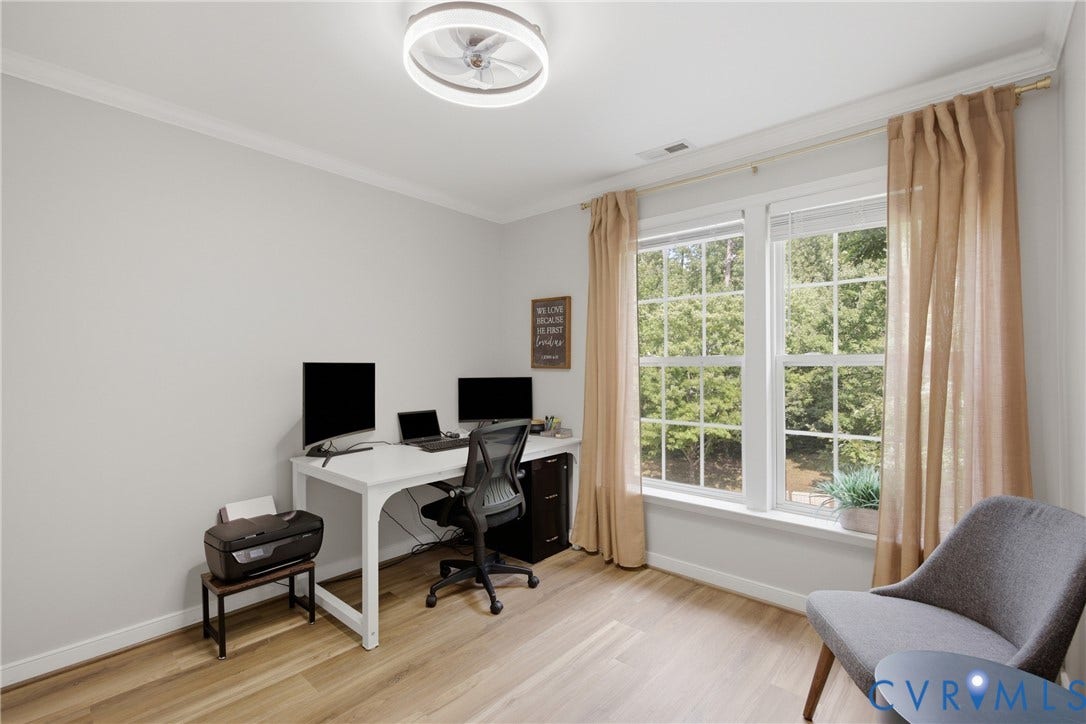 Room featuring light-toned walls, wood-finish flooring, and white crown molding
