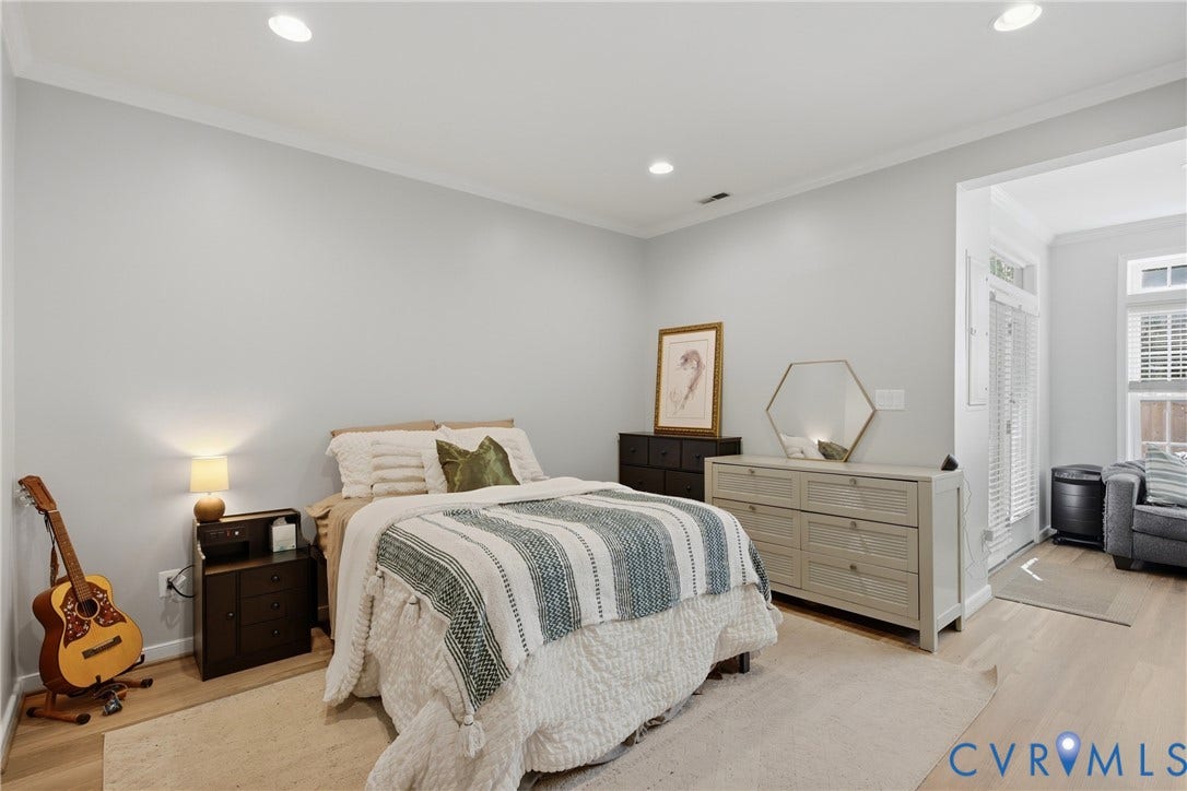 Spacious room featuring light-toned wood-finish flooring, recessed lighting, and crown molding