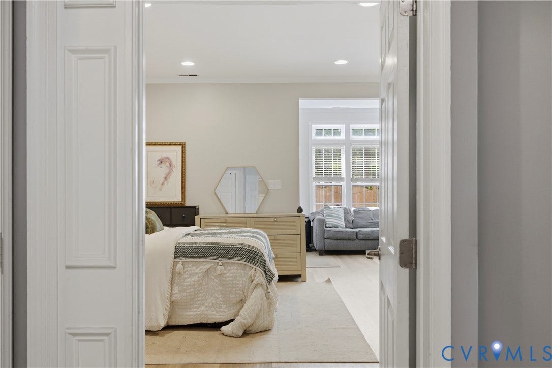 Bright primary bedroom suite featuring neutral wall finishes, recessed ceiling lighting, and hardwood flooring
