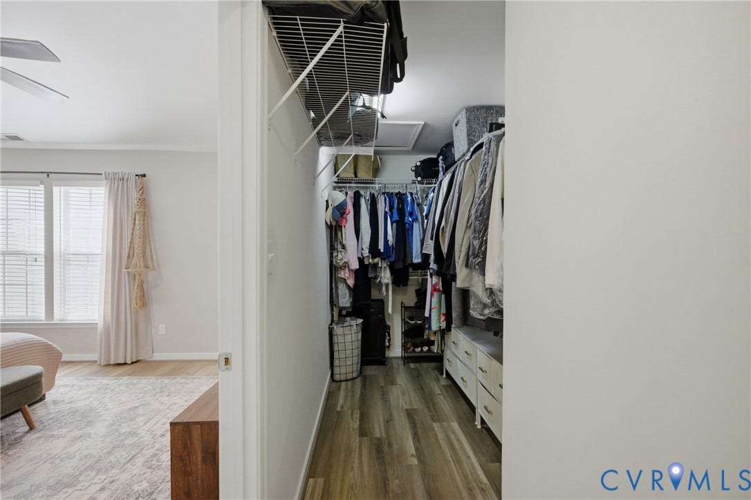Walk-in closet featuring wood-finish flooring, wire shelving, and an integrated ceiling vent