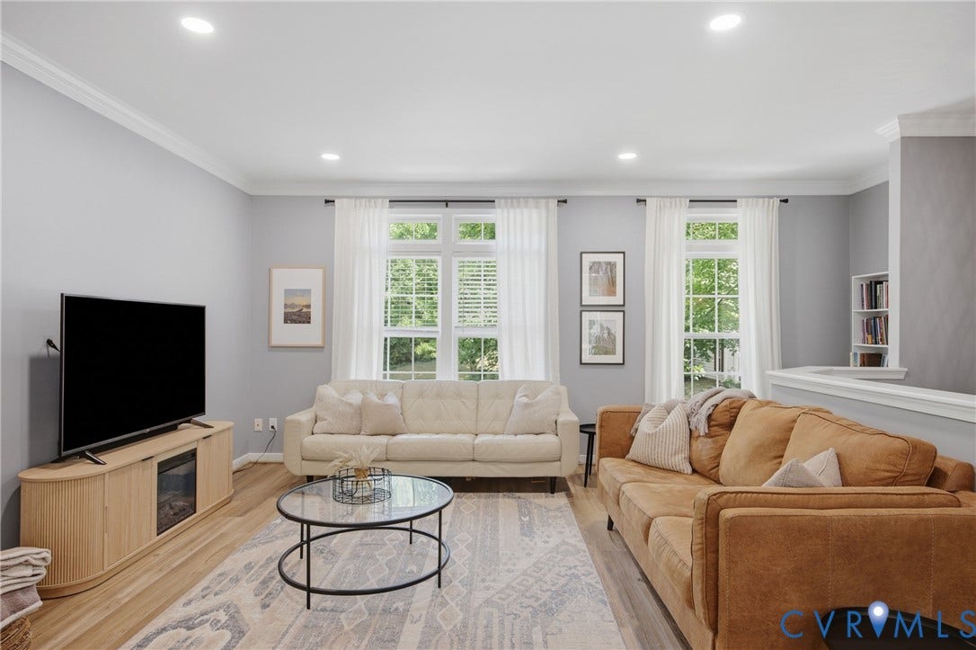 Living area featuring light gray walls, wood-finish flooring, recessed lighting, and crown molding