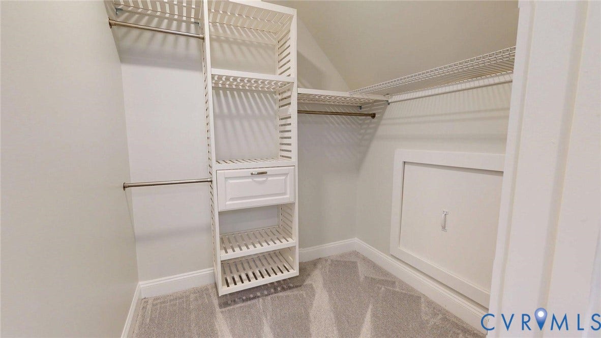 Walk-in closet with built-in shelving, hanging rods, and a drawer unit