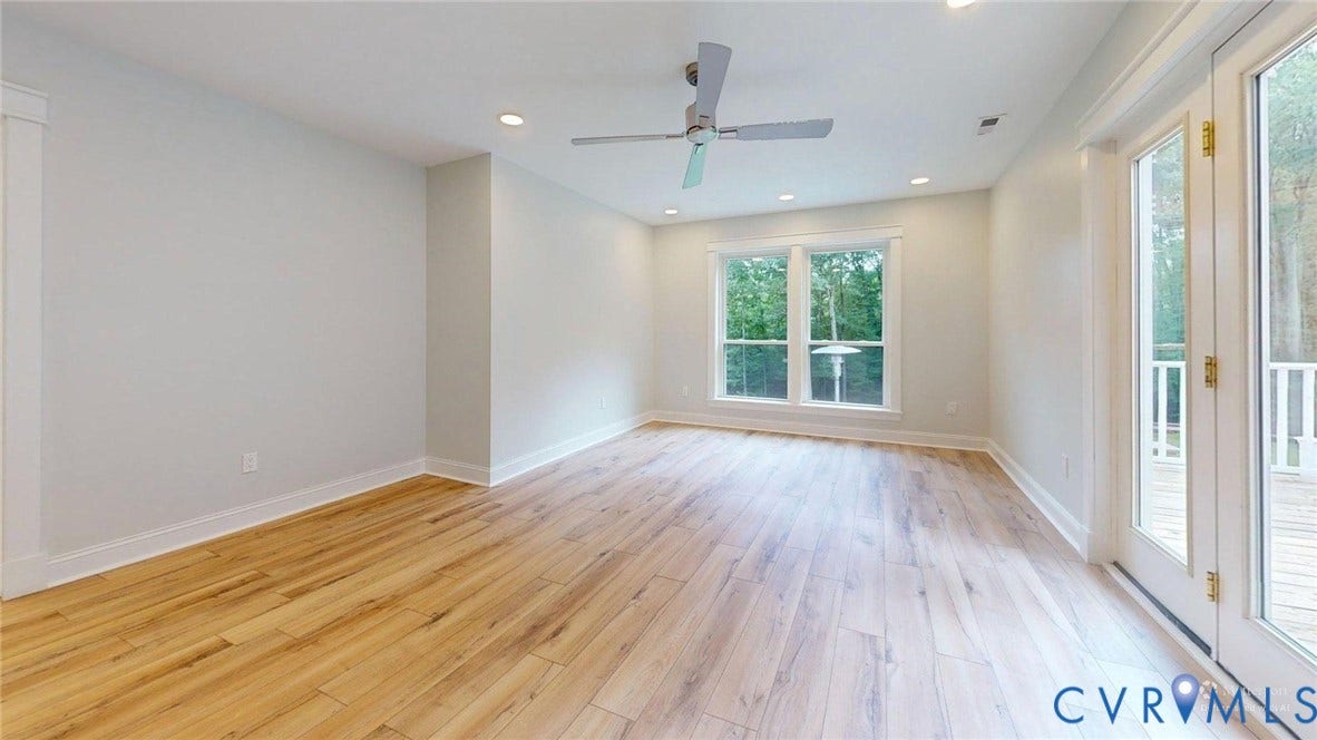Spacious room featuring wood-finish flooring, recessed lighting, and a ceiling fan