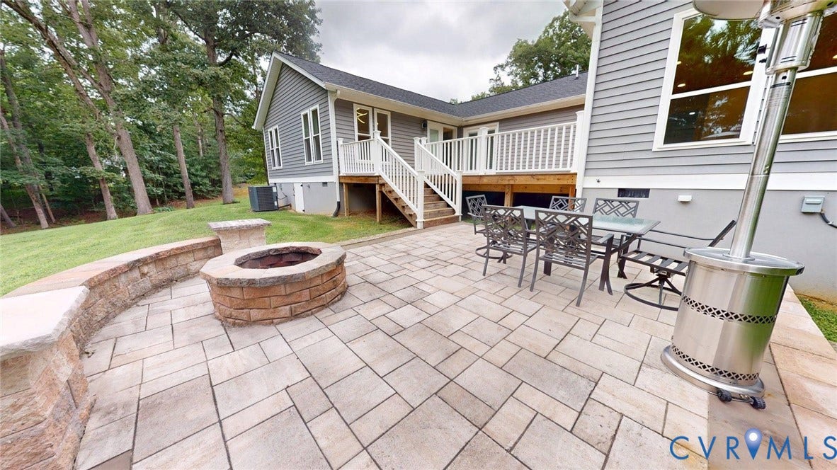 Expansive paver patio featuring a stone-clad fire pit with a matching retaining wall