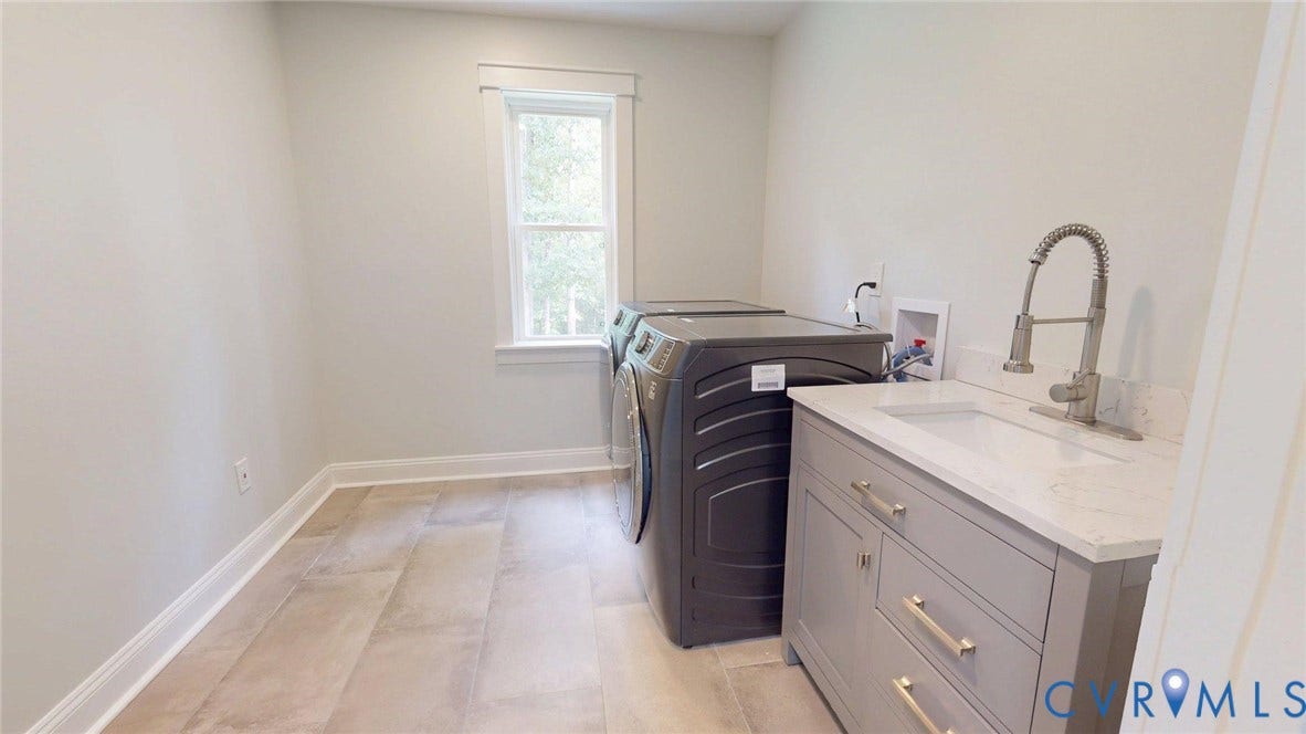 Laundry area featuring a single window, light-toned walls, and wood-finish flooring