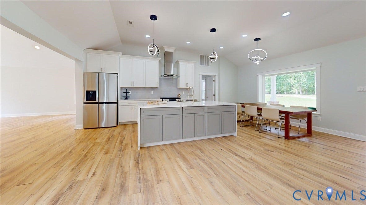 Modern kitchen featuring a large central island with light gray cabinetry and a light-toned countertop