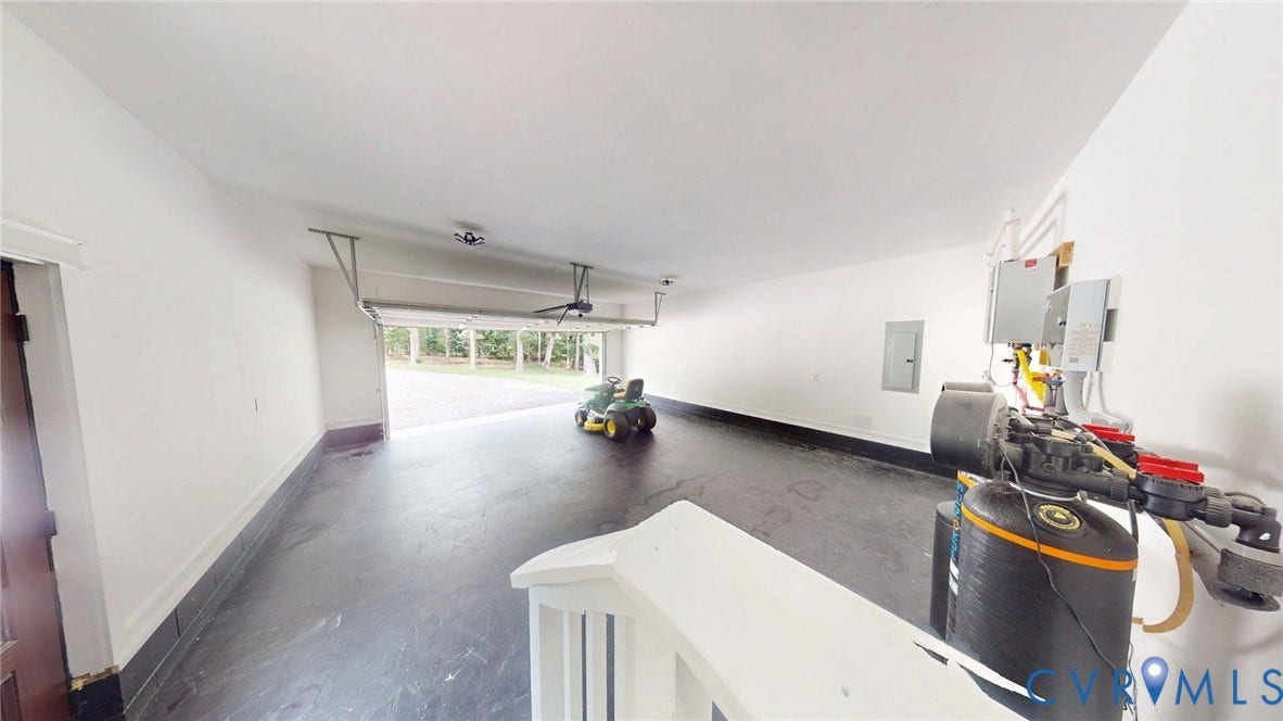 Spacious garage featuring white walls and dark flooring