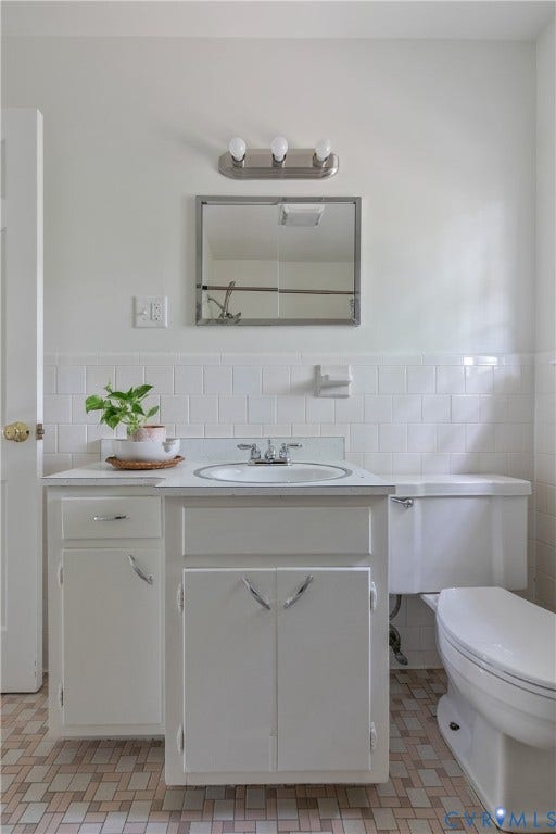 200 Stanmore Road, North Chesterfield, VA 23236 White vanity with integrated sink, chrome faucet, and white subway tile wainscoting