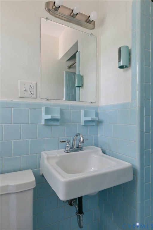 200 Stanmore Road, North Chesterfield, VA 23236 Wall-mounted sink with chrome faucet, light blue subway tile, and a framed mirror with overhead lighting